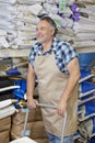 Happy mature man pushing cart in feed store