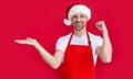 happy mature man in red houseman apron and christmas santa hat