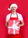 happy mature man in santa hat and red apron hold box Royalty Free Stock Photo