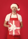 happy mature man in santa hat and red apron hold box Royalty Free Stock Photo