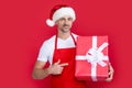happy mature man in santa hat and red apron hold present. boxing day Royalty Free Stock Photo