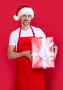 happy mature man in santa hat and red apron hold purchase Royalty Free Stock Photo