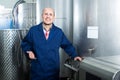 Happy mature man working in wine secondary fermentation section Royalty Free Stock Photo