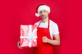 happy mature man in xmas hat and red apron hold present Royalty Free Stock Photo