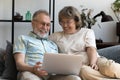 Happy mature married couple using laptop on sofa Royalty Free Stock Photo