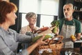 Mature middle-aged woman brings fresh vegetables from country to her friends to make healthy dinner