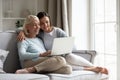 Happy mature mother and daughter sitting on couch, using laptop Royalty Free Stock Photo