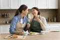 Happy mature mother and adult daughter woman eating homemade sandwiches