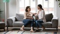 Happy mature mother and grownup daughter relaxing on couch together