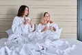 Happy mature mother and teenage daughter drinking coffee, talking, smiling Royalty Free Stock Photo