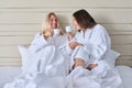 Happy mature mother and teenage daughter drinking coffee, talking, smiling Royalty Free Stock Photo