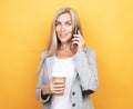 Happy mature old 60s woman with long hair holding smartphone and takeaway coffee Royalty Free Stock Photo