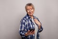 Happy mature old 60s woman, older middle aged female customer holding smartphone using mobile app, texting message Royalty Free Stock Photo