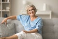 Happy mature old woman in glasses resting on soft couch Royalty Free Stock Photo