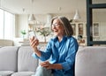 Happy mature old woman holding smartphone using mobile phone app for video call.