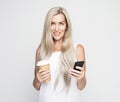 Happy mature old woman with long hair holding smartphone and takeaway coffee over grey background Royalty Free Stock Photo
