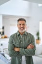 Happy mature older man standing with arms crossed at home. Vertical portrait. Royalty Free Stock Photo