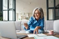 Happy mature older woman video calling on laptop working from home. Royalty Free Stock Photo
