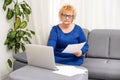 Happy mature older woman video calling on laptop working from home. Smiling 60s middle aged businesswoman talking by Royalty Free Stock Photo