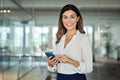 Happy mature professional business woman using phone at office, portrait. Royalty Free Stock Photo