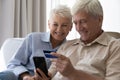 Happy mature couple of customers using smartphone for online shopping Royalty Free Stock Photo