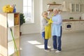 Happy mature romantic couple standing and dancing after cleaning home together Royalty Free Stock Photo