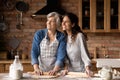 Happy mature 60s mother and grown daughter woman baking pie Royalty Free Stock Photo