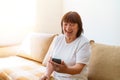 Happy mature 60s old woman holding smartphone with mobile phone app for video Royalty Free Stock Photo