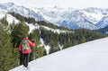 Senior man is snowshoe hiking in alpine snow winter mountains. Allgau, Bavaria, Germany. Royalty Free Stock Photo