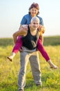 Happy mature woman climbed on her husband in the park
