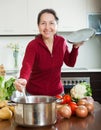 Happy mature woman cooking lent diet soup