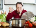 Happy mature woman cooking lent diet soup Royalty Free Stock Photo