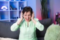 Happy Mature Woman on Headphones Dancing in Home. Aged Female Having Fun Listening Music Using Headset in Modern Royalty Free Stock Photo