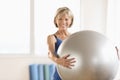 Happy Mature Woman Holding Yoga Ball At Home