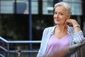 Happy mature woman near metal handrail on street, space for text. Smart aging Royalty Free Stock Photo
