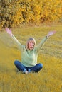 Happy mature woman with raised arms