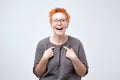 Happy mature woman with red hair pointing fingers at herself. Select me please concept Royalty Free Stock Photo