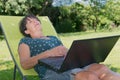 Happy mature woman relaxing resting on the deck chair in garden Royalty Free Stock Photo