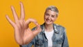 Happy mature woman showing okay gesture and smiling at camera Royalty Free Stock Photo