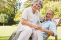 Happy mature woman sitting on her husband on deck chair Royalty Free Stock Photo