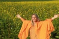 Happy mature woman with spread arms in flower field Royalty Free Stock Photo