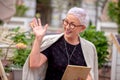 Happy mature woman in stylish outfit is greeting her friend in the street Royalty Free Stock Photo