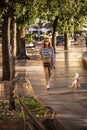 Happy mature woman taking out the dog for the morning walk at the city Royalty Free Stock Photo