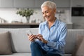 Happy Mature Woman Using Smartphone Gadget And Applications At Home Royalty Free Stock Photo