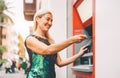 Happy mature woman withdraw money from bank cash machine with debit card - Senior female doing payment with credit card in ATM Royalty Free Stock Photo