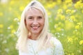 Happy matured woman in flowerfield