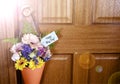 Happy May Day gift of flowers on door with lens flare. Royalty Free Stock Photo