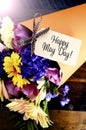 Happy May Day traditional gift of Spring Flowers with lens flare. Royalty Free Stock Photo