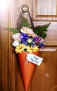 Happy May Day gift of flowers on door with lens flare. Royalty Free Stock Photo