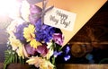 Happy May Day traditional gift of Spring Flowers with lens flare. Royalty Free Stock Photo